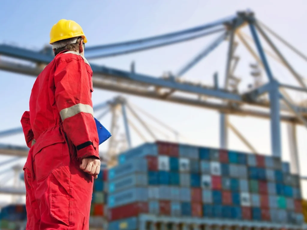 Mann steht vor einem Container Schiff